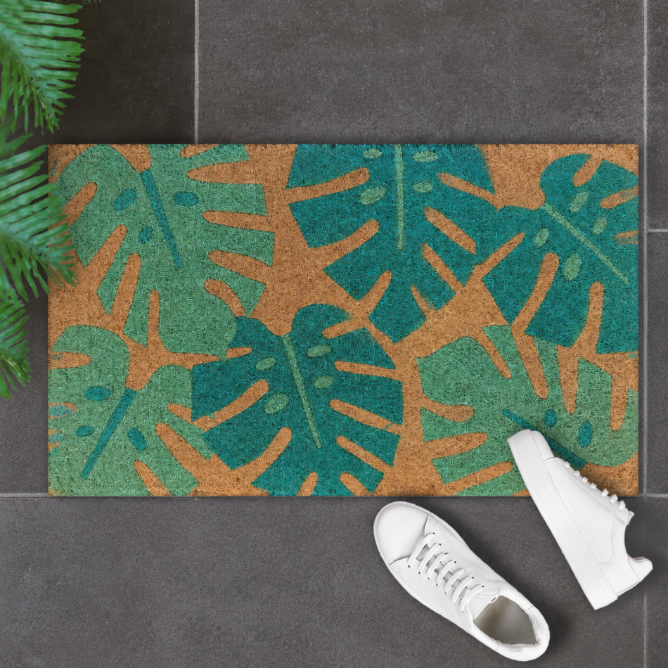 Monstera palm leaf coir doormat styled at a sheltered front doorway